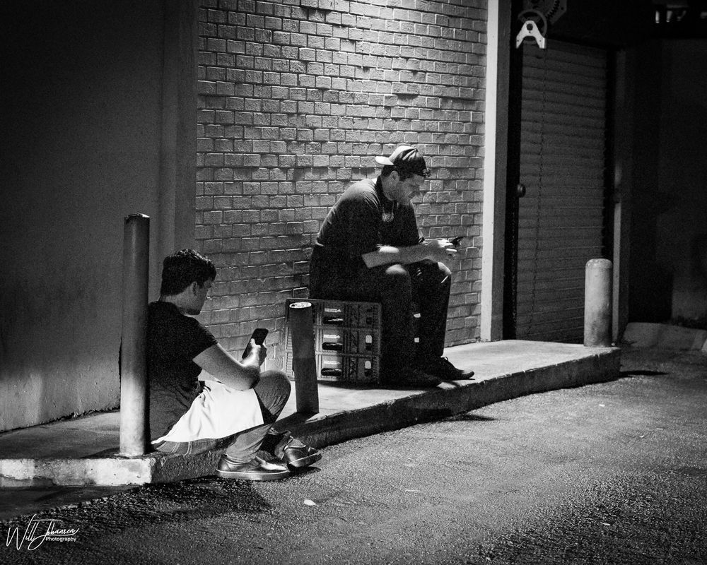 Black and white photo sequence showing a figure crouching in a dimly lit brick corridor.