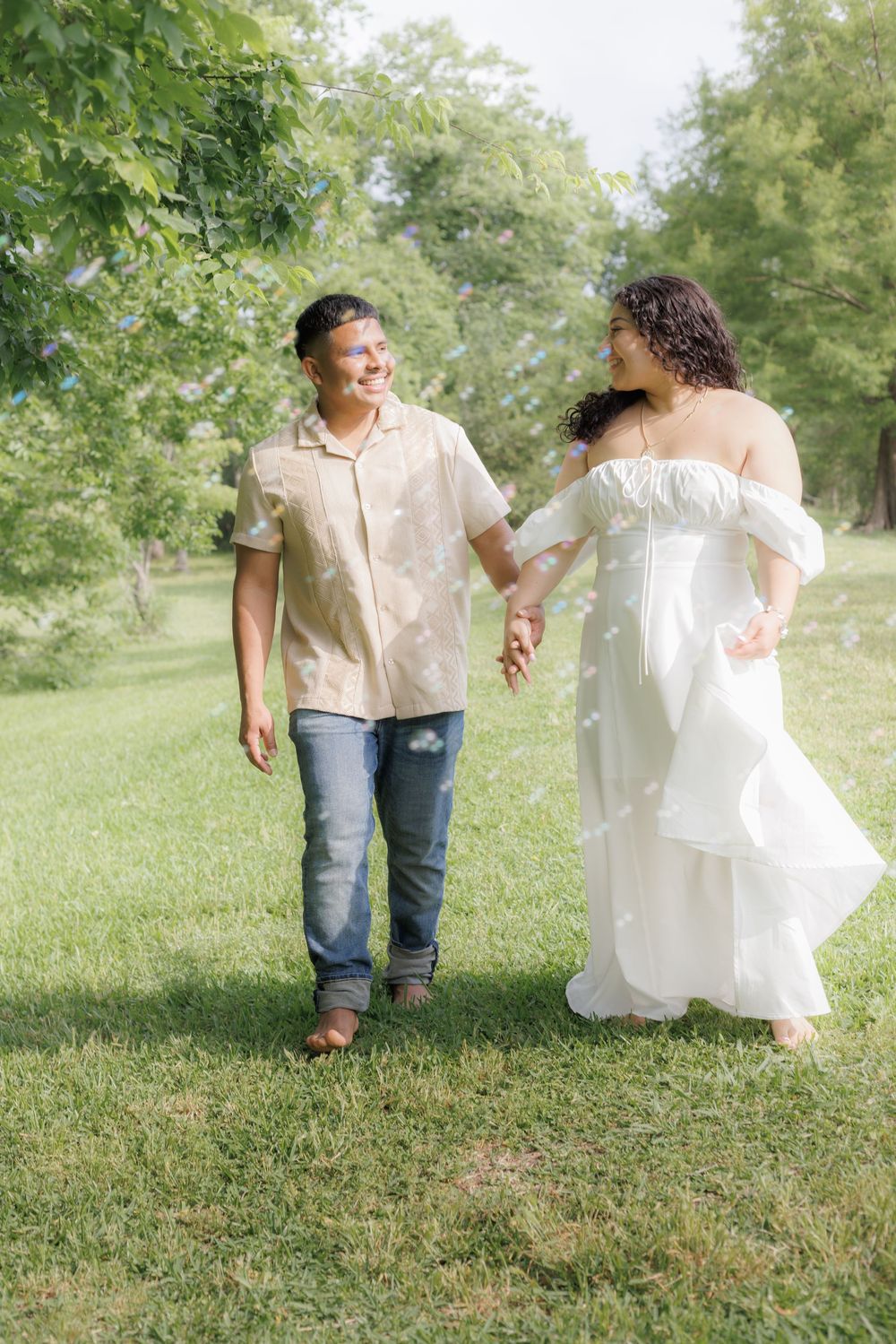 outdoor couple session where the couple is walking down the green field.