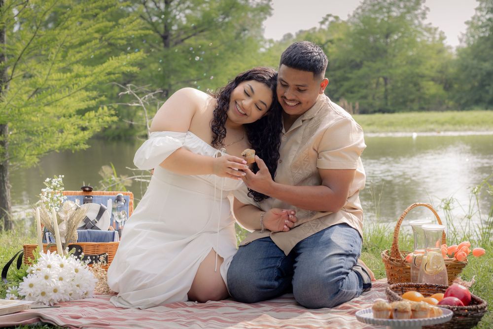 Outdoor couple session in a picnic setting, while couple shares a muffin.