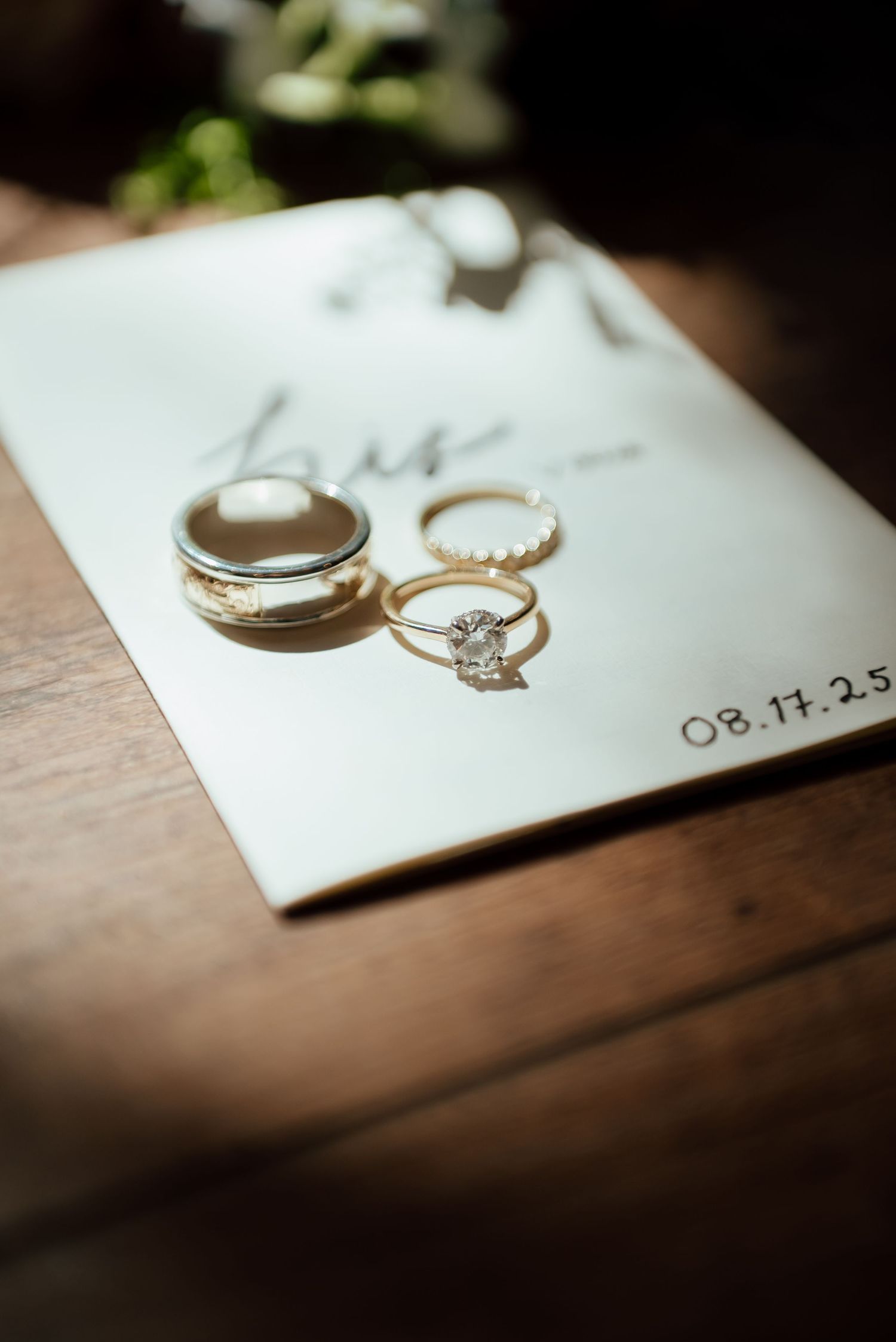 Two hands with silver rings make a pinky promise against a soft blurred background.