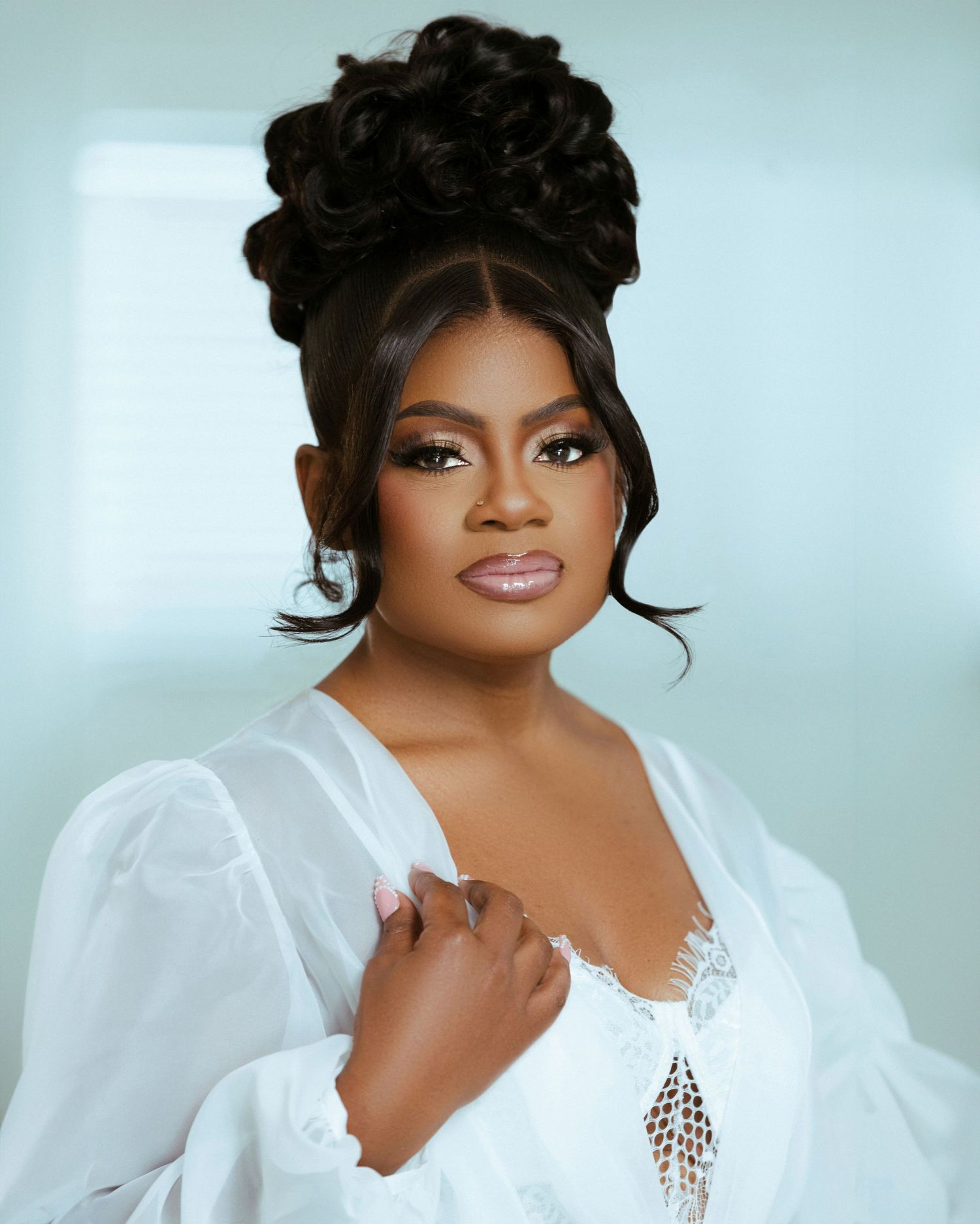 Glamorous bridal portrait featuring an elegant white lace robe and sophisticated updo hairstyle.