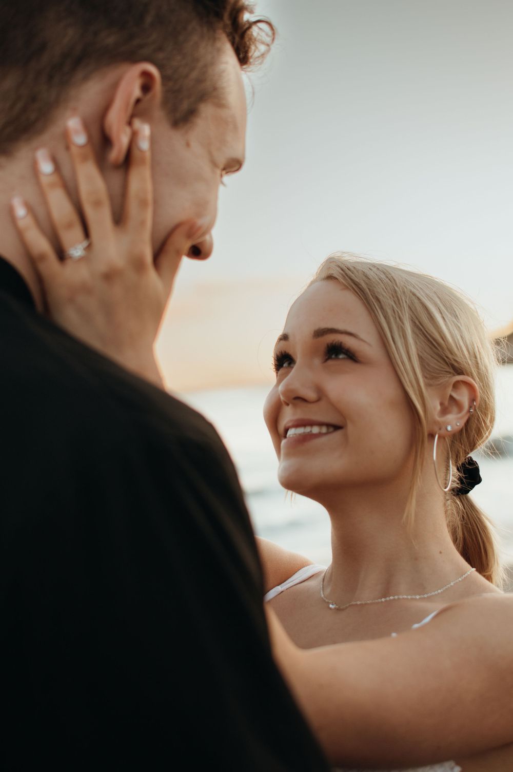 Intimate close-up of couple sharing loving glance during sunset engagement photoshoot.