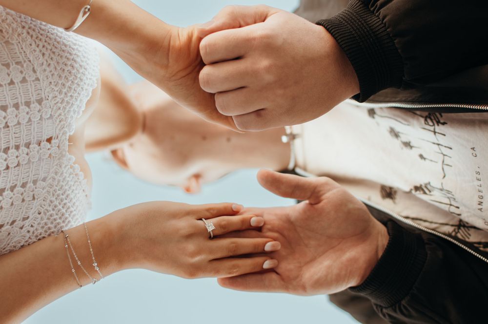 Close-up shot of hands exchanging rings during wedding ceremony.