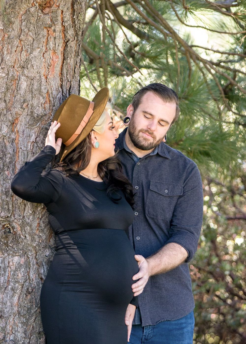 Outdoor maternity photo at Lake Cuyamaca with mom in black dress and dad holding her belly. San Diego maternity photographer