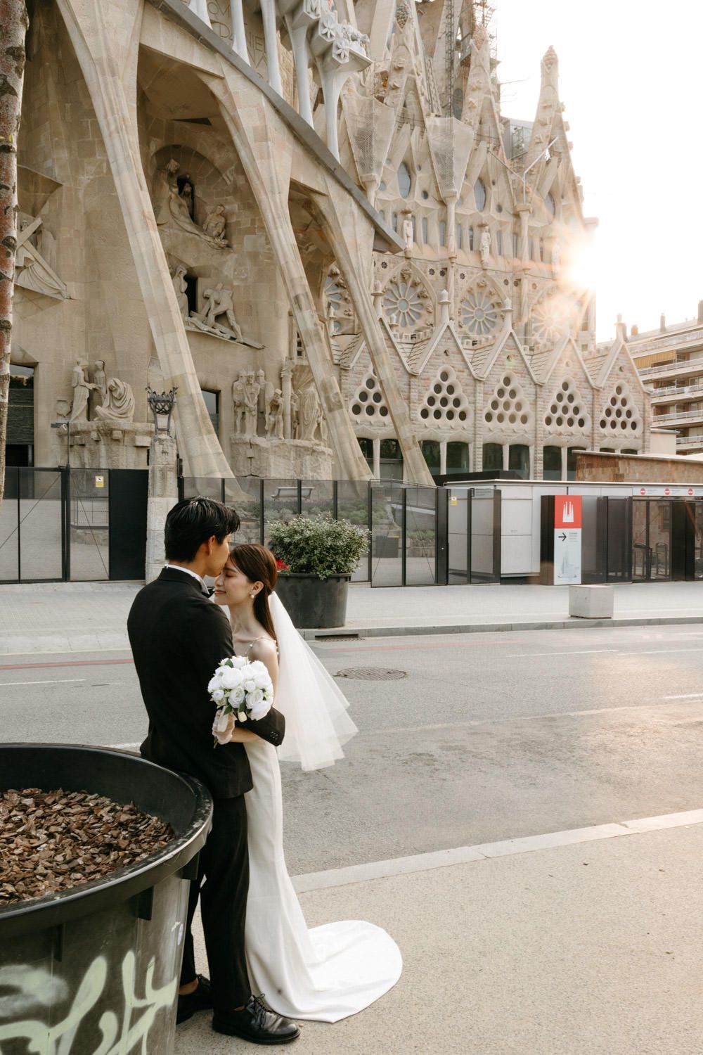 Romantic wedding couple shares intimate moment outside Sagrada Familia cathedral.