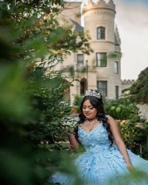 Sky blue formal gown captured against the backdrop of a historic stone castle.