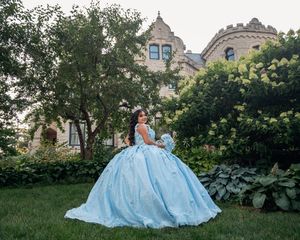 Flowing light blue ballgown photographed on castle grounds with lush greenery.
