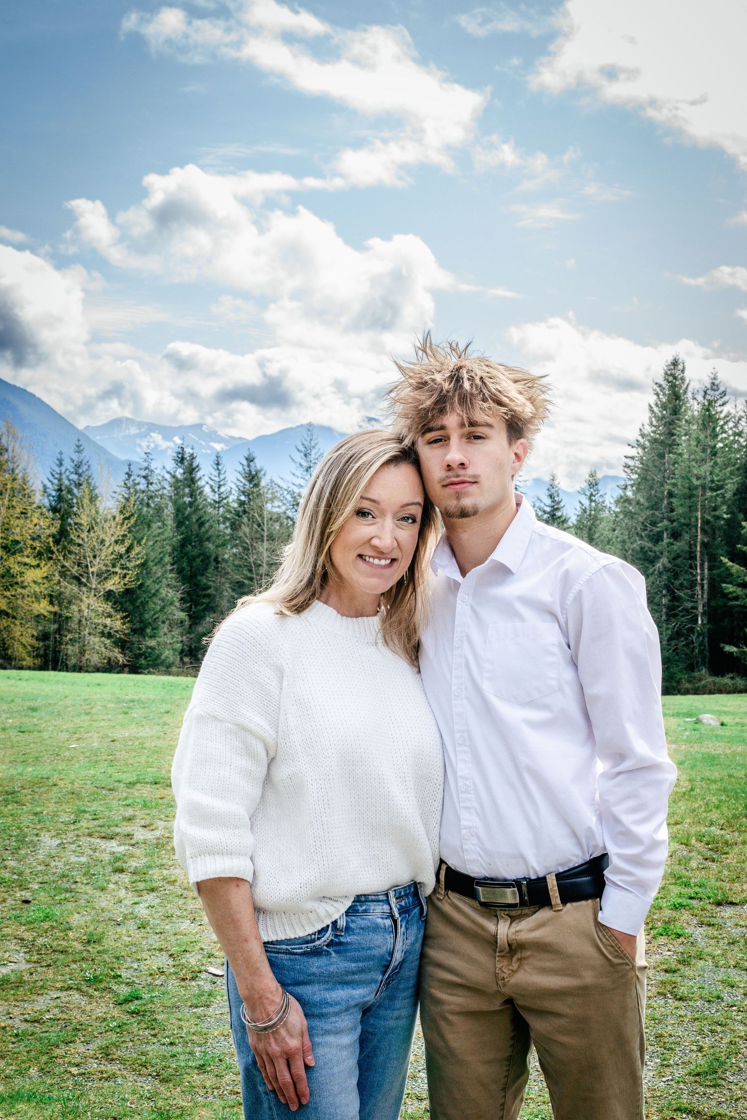 Outdoor mother and son portrait with mountains and blue skies in the background, Snoqualmie Point Park. Seattle graduation photography.