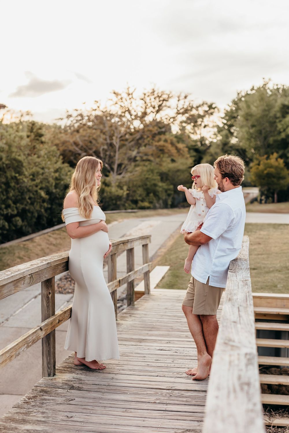 Family sharing special moment on wooden boardwalk at sunset.