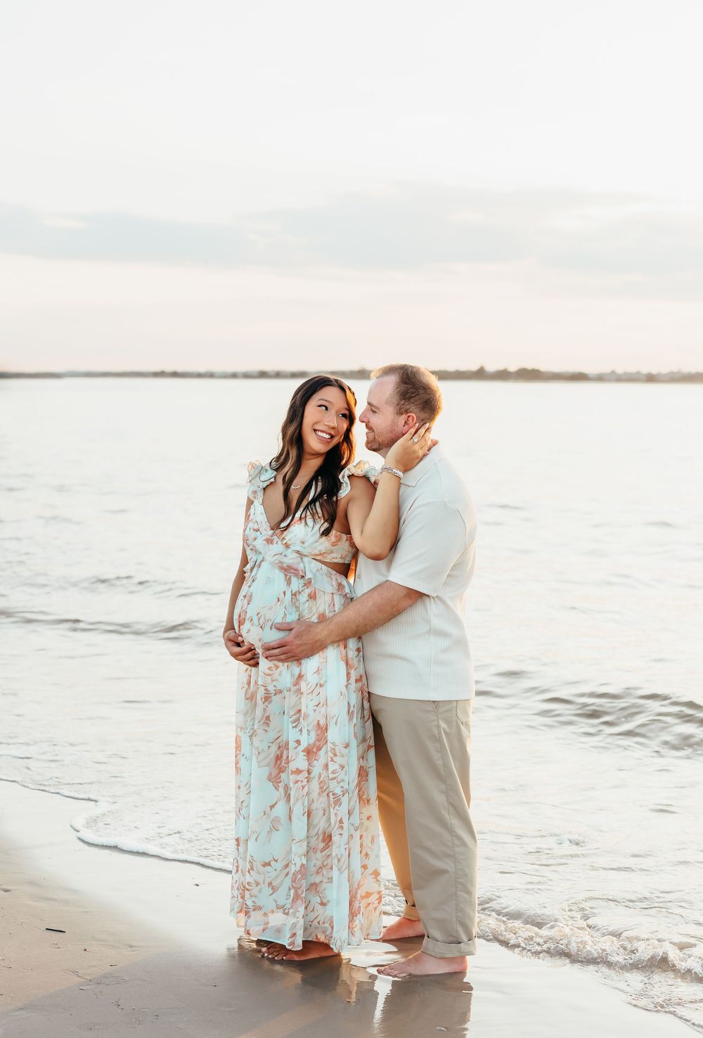 Romantic beach portraits of couple sharing intimate moments by ocean at sunset.