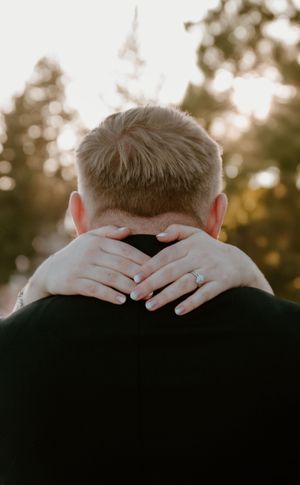 Hands gently embrace the back of a head in a romantic silhouette against a soft sunset background, in Tahoe