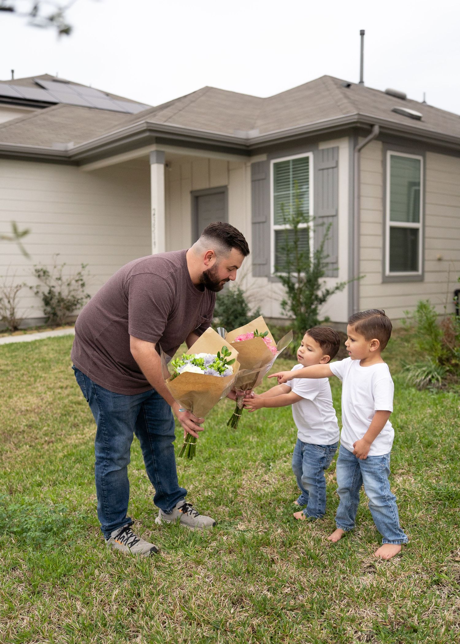 Dad reading gender reveal results to the family while kids excitedly wait to hand Mom the correct bouquet