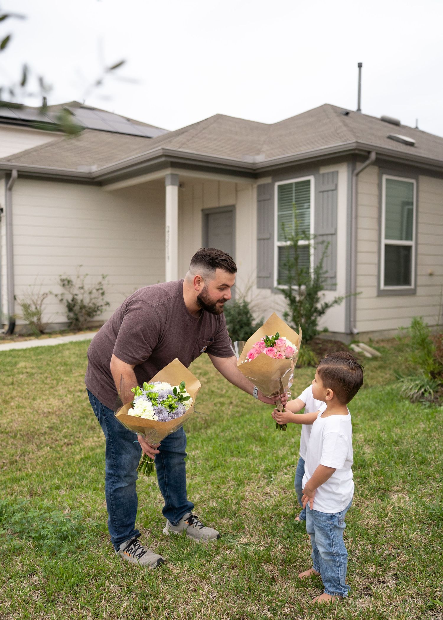 Dad reading gender reveal results to the family while kids excitedly wait to hand Mom the correct bouquet