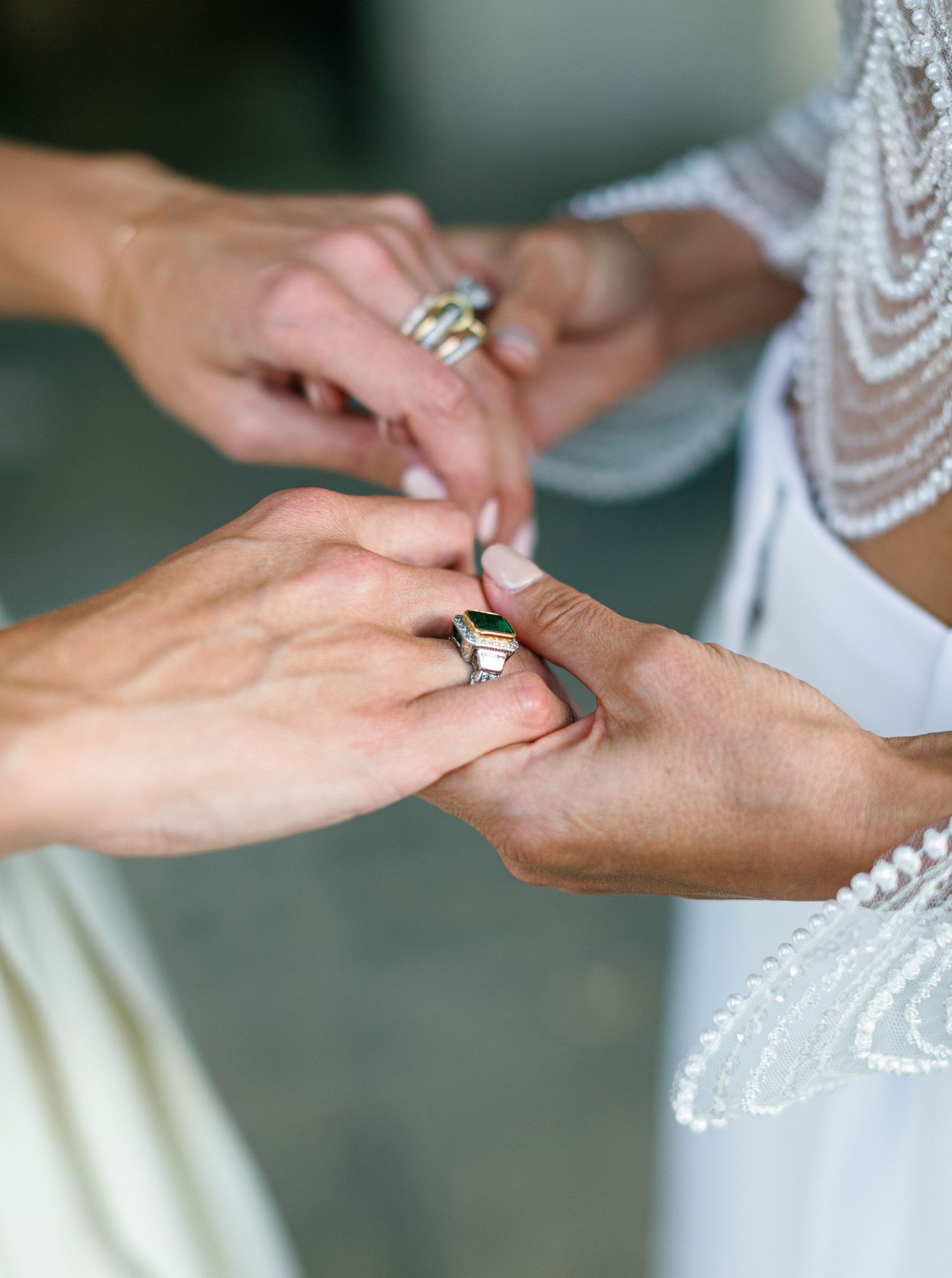Close-up sequence of hands exchanging wedding rings during an elegant ceremony with lace details.