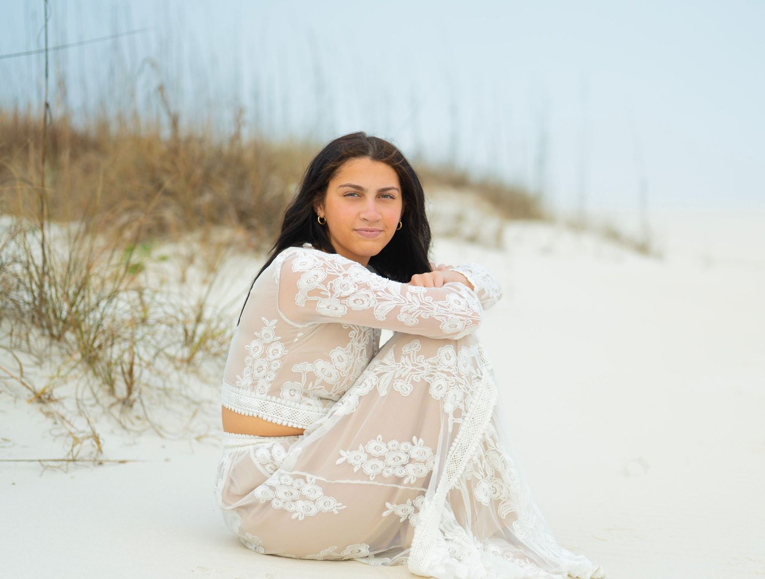 Ethereal beach portraits featuring romantic white lace dress and natural coastal scenery.