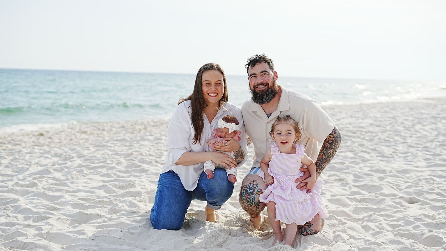Family enjoying quality time together on a pristine white sandy beach during a sunny day.