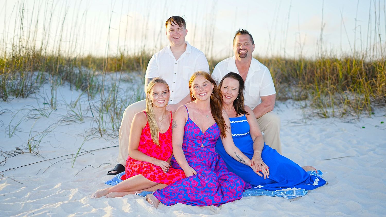 People enjoying a relaxing day at a white sandy beach during sunset.