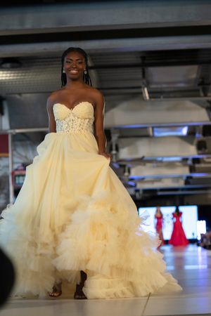 A voluminous cream-colored tulle ballgown with a sweetheart neckline being showcased on a fashion runway.
