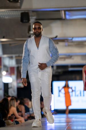 All-white ensemble with denim accents displayed during fashion show.