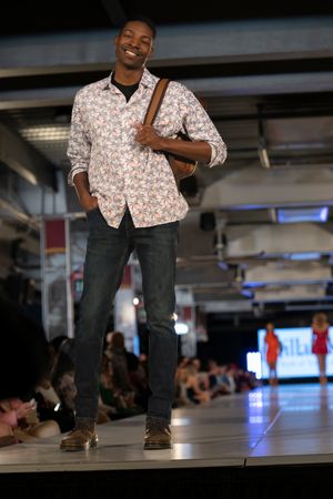 Floral print shirt paired with dark jeans shown at fashion event.