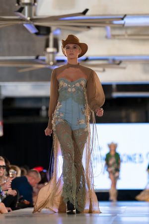 Ethereal blue dress with sheer overlay presented at fashion show.