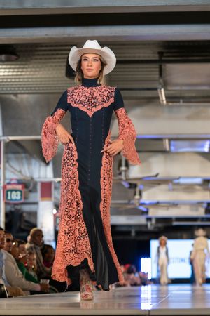 Western-style dress with coral lace details and navy center panel on runway.