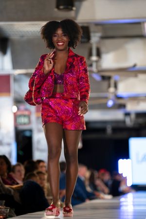 Vibrant hot pink patterned ensemble with matching accessories on fashion catwalk.