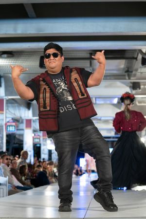 Sequence of dance moves performed on a runway stage showing energetic poses in casual street wear.