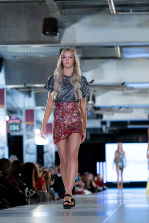 Sequined red and silver mini dress showcased on fashion runway.
