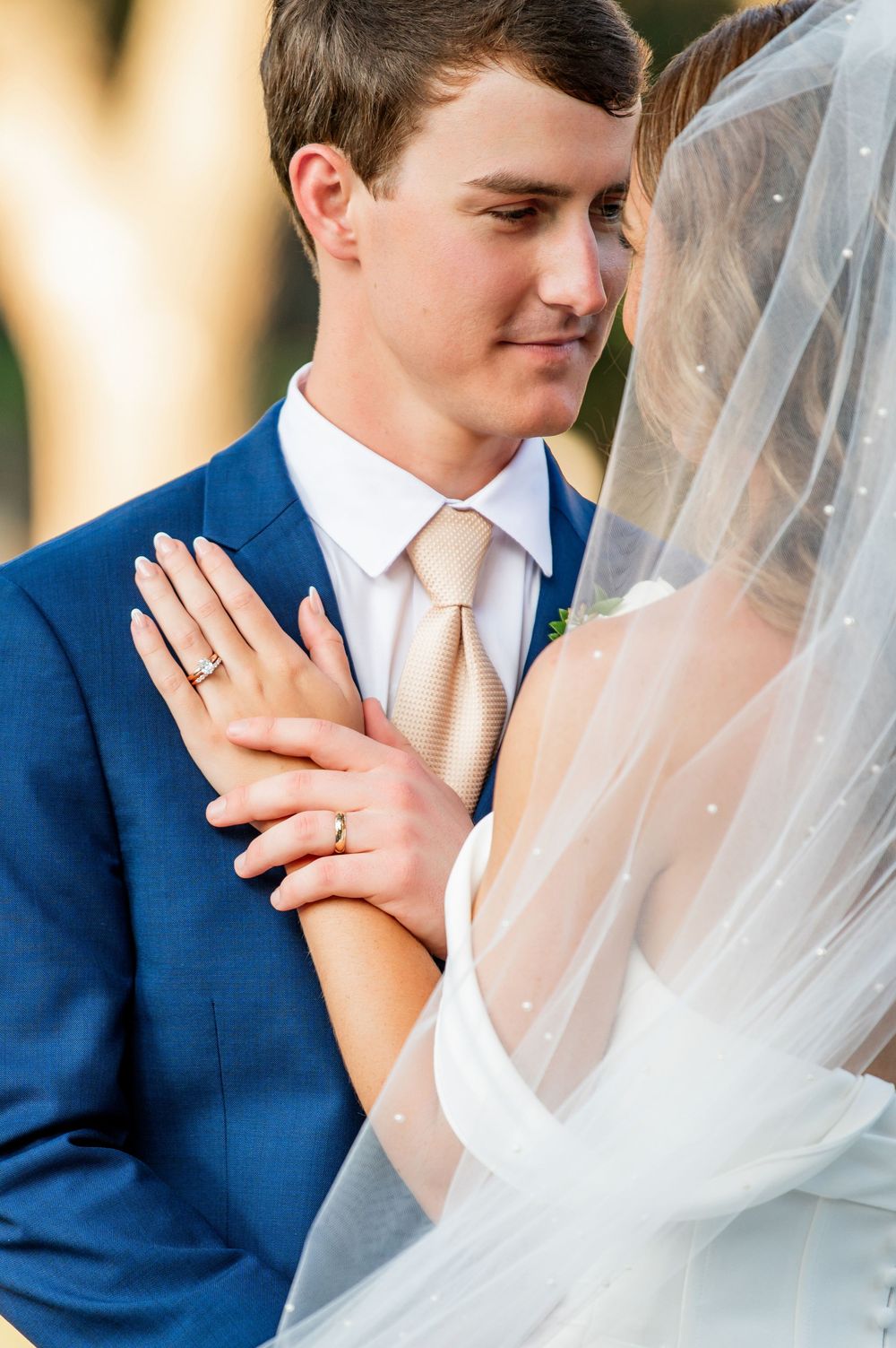 Close-up wedding portrait showing delicate veil details and intimate moment.