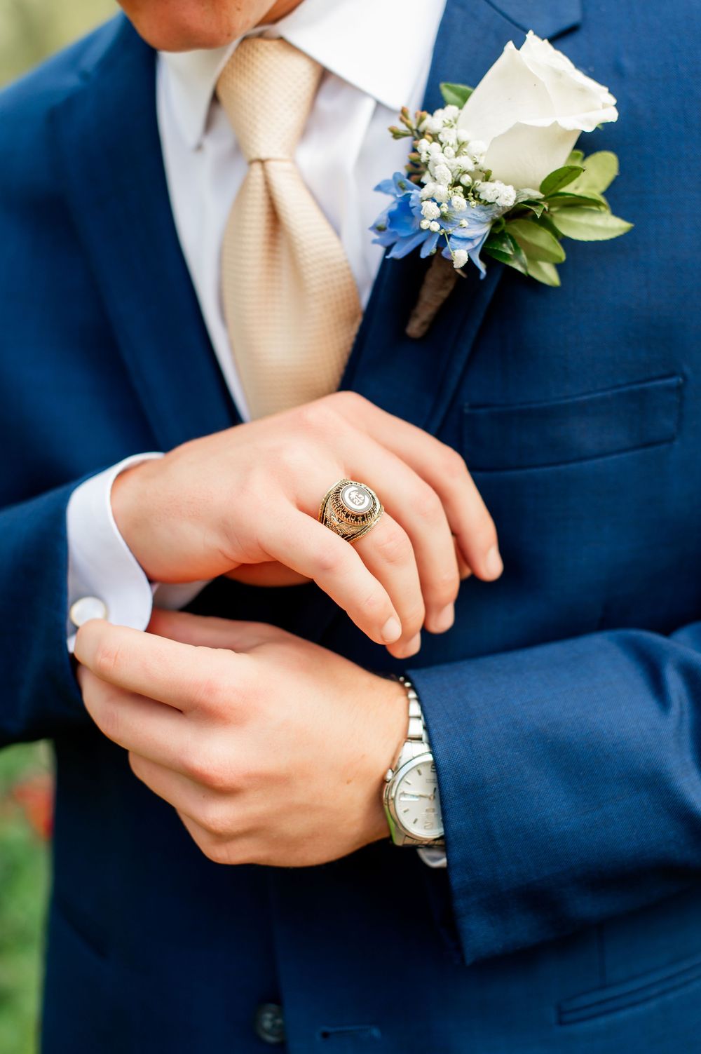 Detail shots of groom's accessories including blue suit, champagne tie, and floral boutonniere.