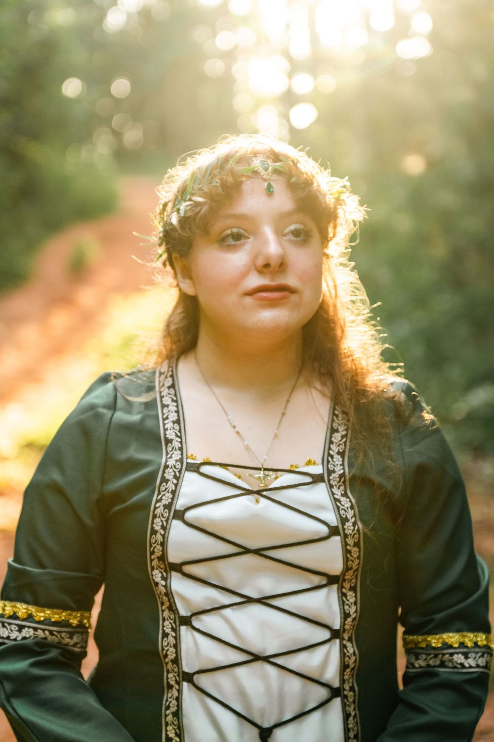 A series of portraits in a medieval-inspired dress with lace-up bodice and gold trim captured in warm sunset lighting.