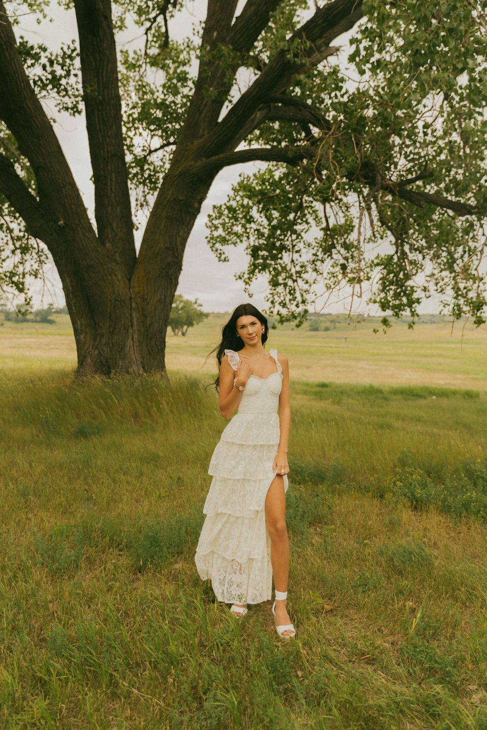 Elegant poses beneath majestic oak trees in a tiered white summer dress.