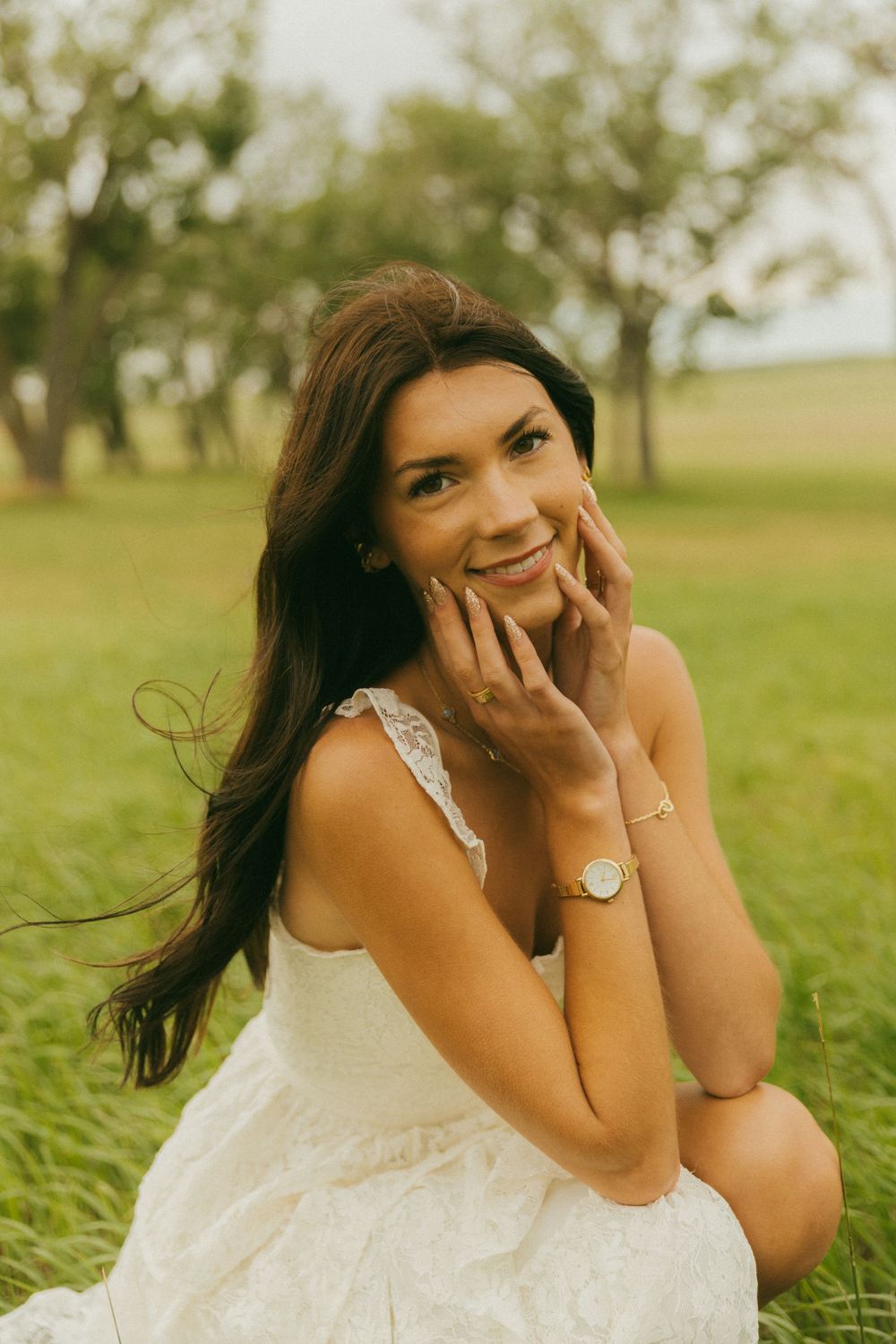 Carefree laughter captured in a white summer dress against a grassy landscape.