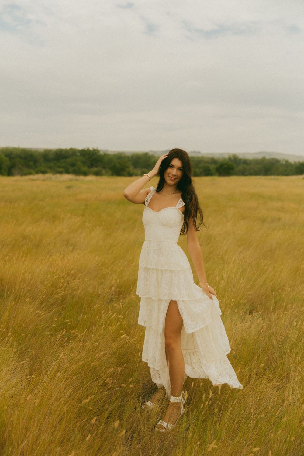 Carefree summer photoshoot in a sun-drenched field with a flowing white dress.