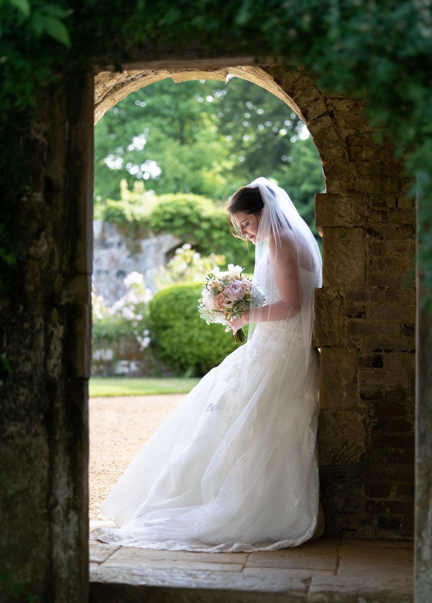 Editorial wedding portrait in historic garden archway in Kent country house