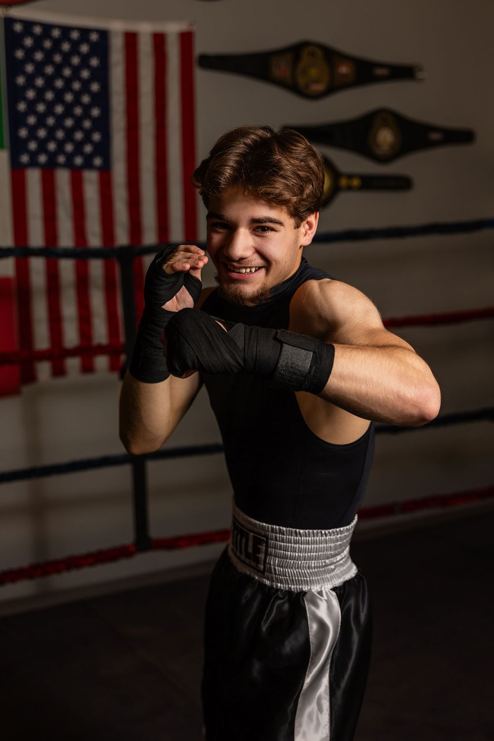 A sequence of boxing poses against an American flag backdrop in a dimly lit gym setting. - senior photos in Omaha, NE