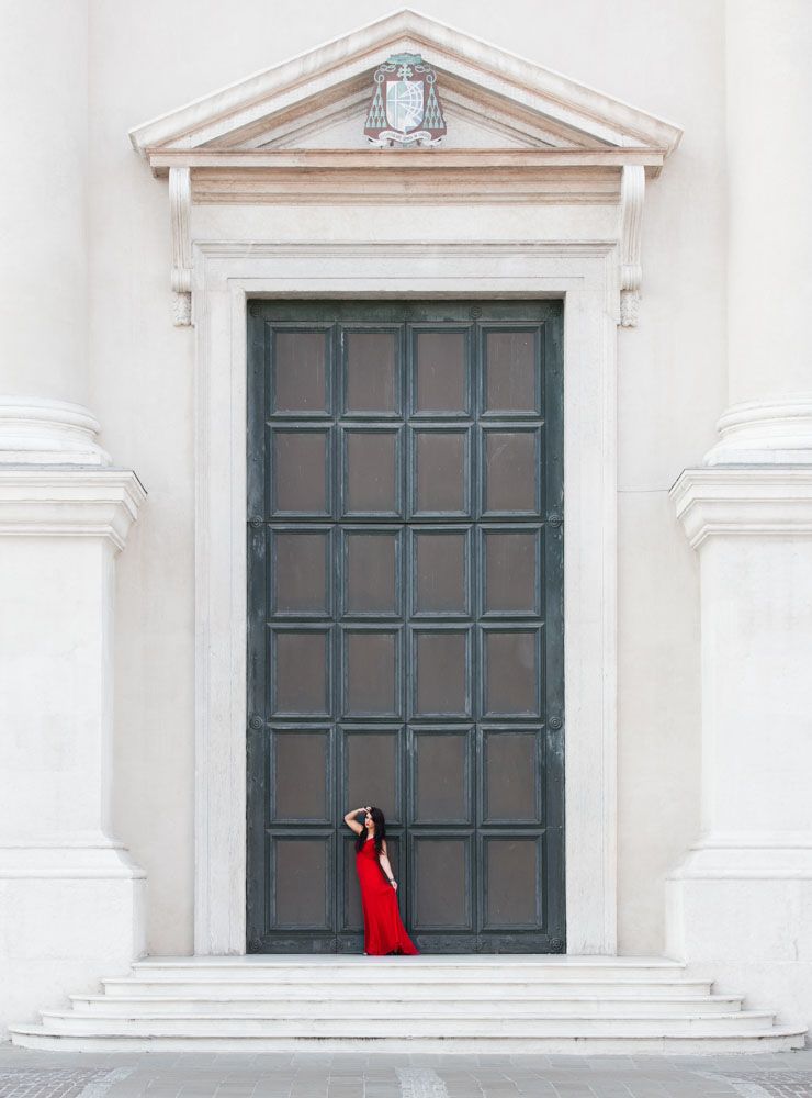 Striking shot of fashionable woman framed by huge doorway in old city