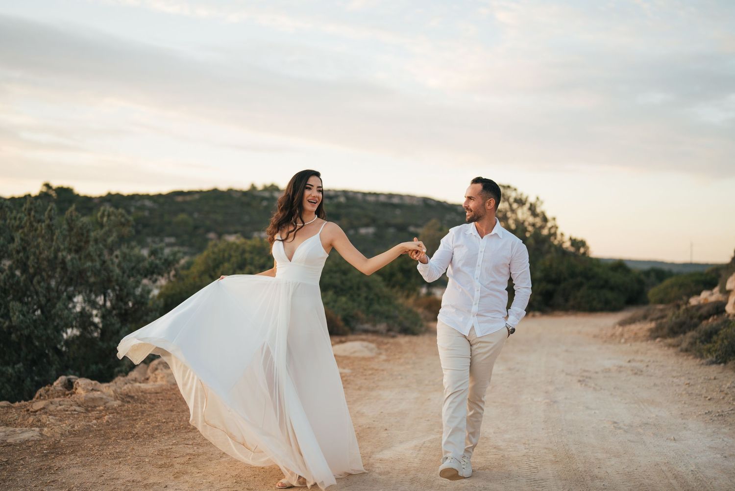 Romantic wedding couple photoshoot on a desert path at sunset.