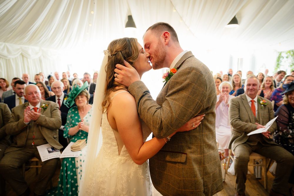 A romantic wedding sequence showing intimate moments between newlyweds during their celebration under a white tent.