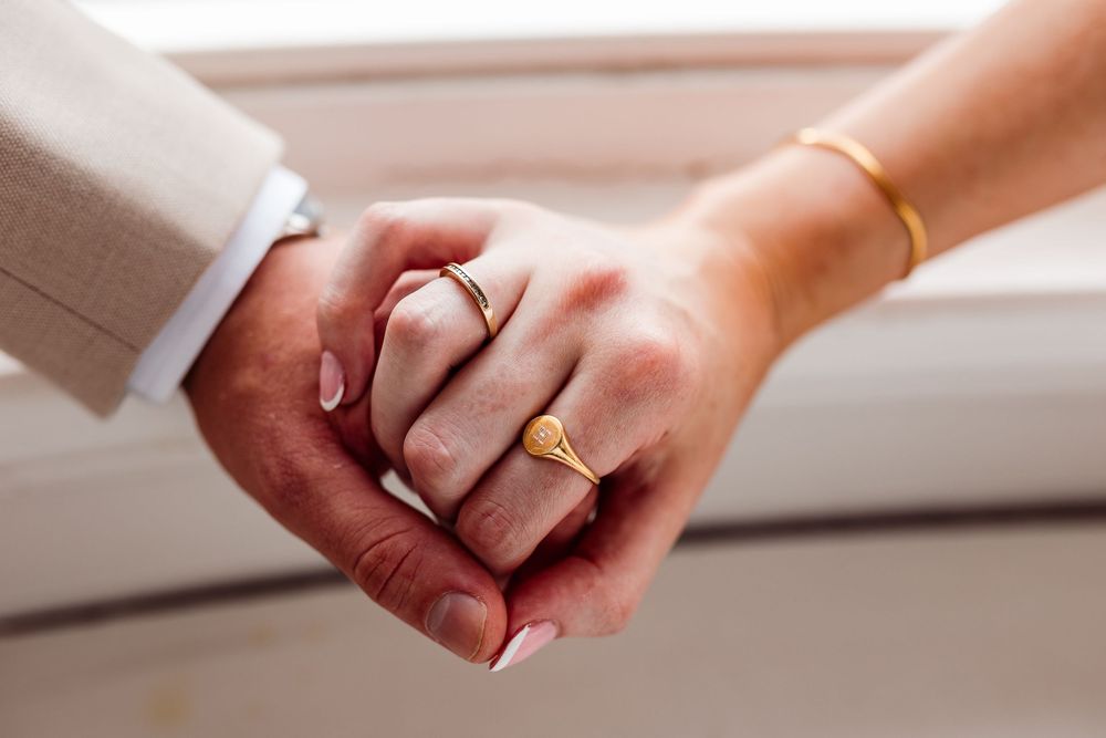 Hands holding and passing a gold ring in a sequence of photos showing the progression of a ring exchange.