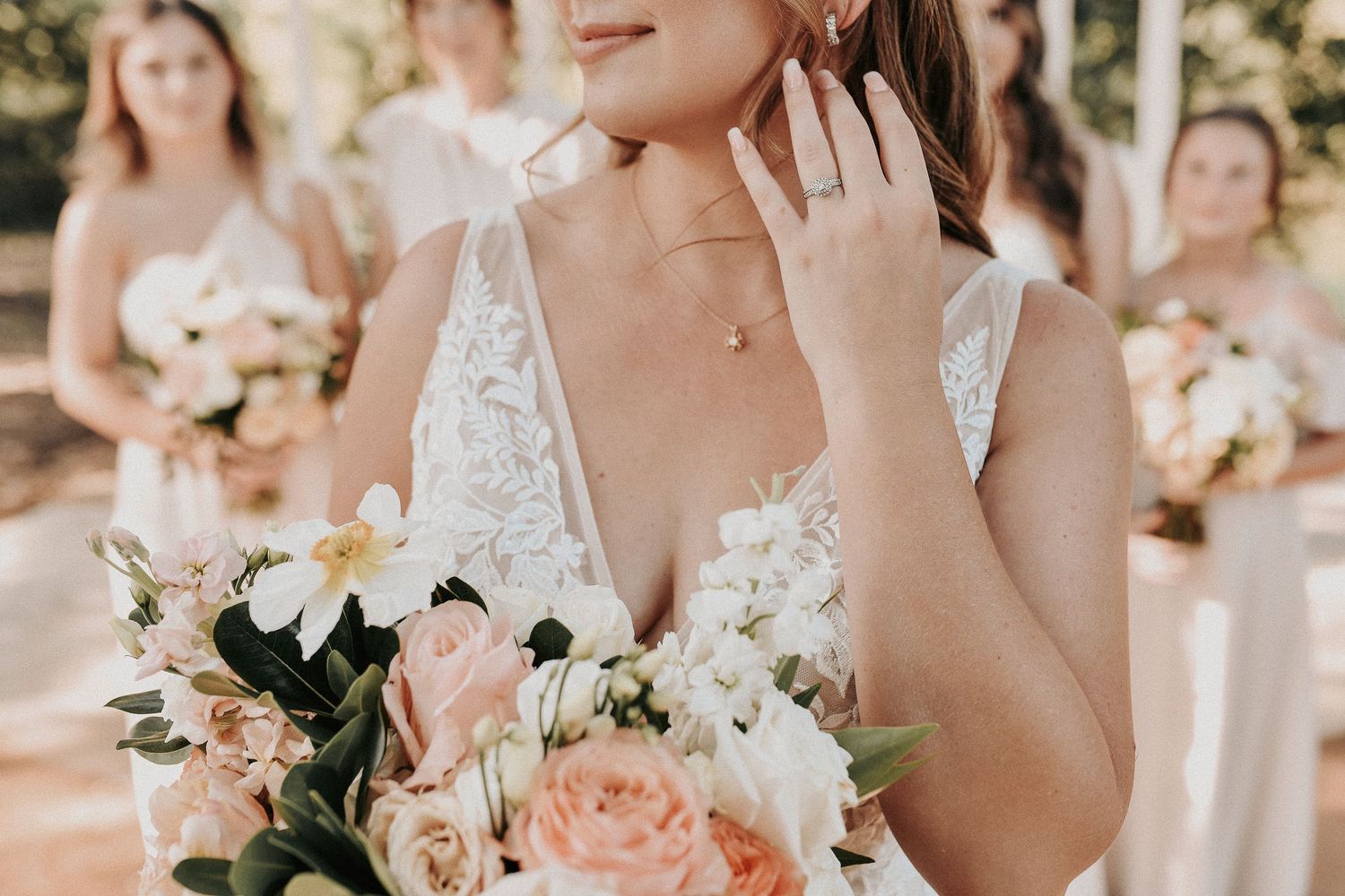 Bridesmaids posing together in soft pink dresses during a spring wedding at Towering Oaks Wedding Venue.