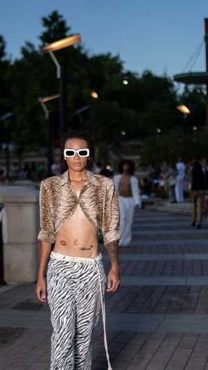 Edgy streetwear look featuring metallic jacket and zebra print pants with white sunglasses.