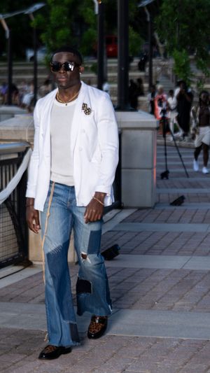 Classic white blazer paired with distressed jeans and sunglasses for casual luxury styling.
