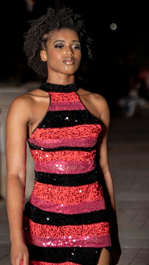 Sequined dress with alternating black and coral stripes creates a stunning evening look on the runway.