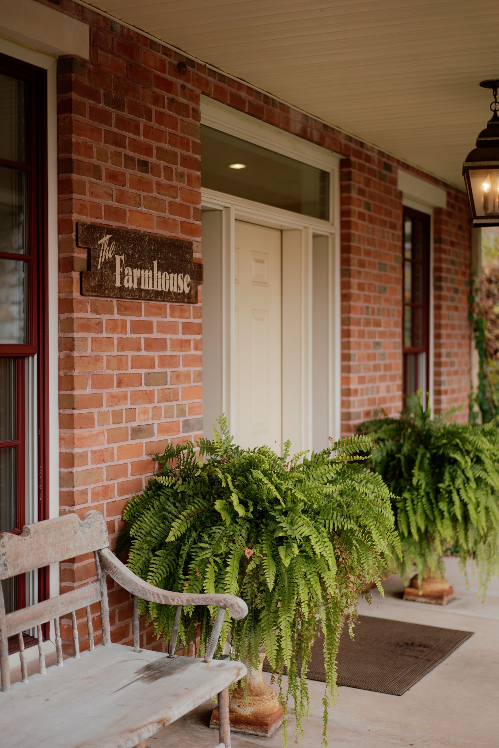 Red brick building exterior with hanging ferns and white trim details.