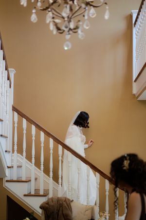White banister staircase with crystal chandeliers in an elegant interior setting.