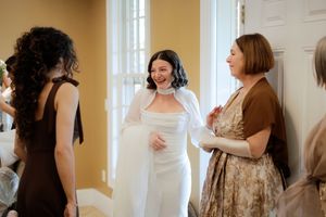 Wedding party getting ready in a warm-toned room with natural window light.