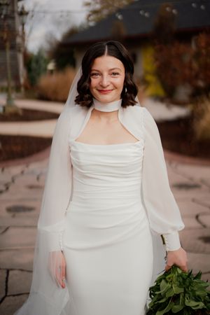 A bride in a white dress with long sleeves poses outdoors in a series of candid shots.