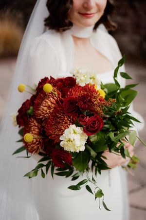 Autumn wedding bouquet with deep red chrysanthemums and white flowers.
